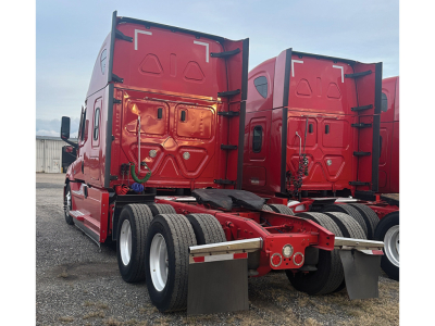 Truck rear view showing Freightliner Cascadia126 tractor with red cab and dual rear axles, fifth wheel area, and mud flaps.