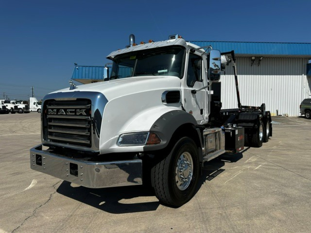 Mack GR64B truck in white profile showing front grille with Mack lettering and chrome bumper.