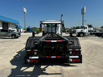Rear view of 2027 Mack GR64B roll-off truck showing chassis, taillights, and mud flaps with Galfab branding.