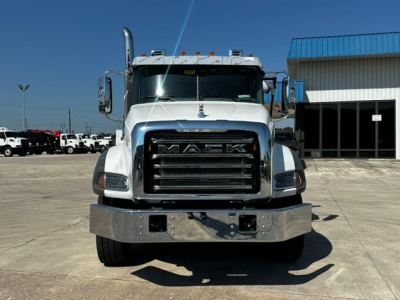 Front view of a white 2027 Mack GR64B roll-off truck showing chrome grille with MACK lettering and large bumper.