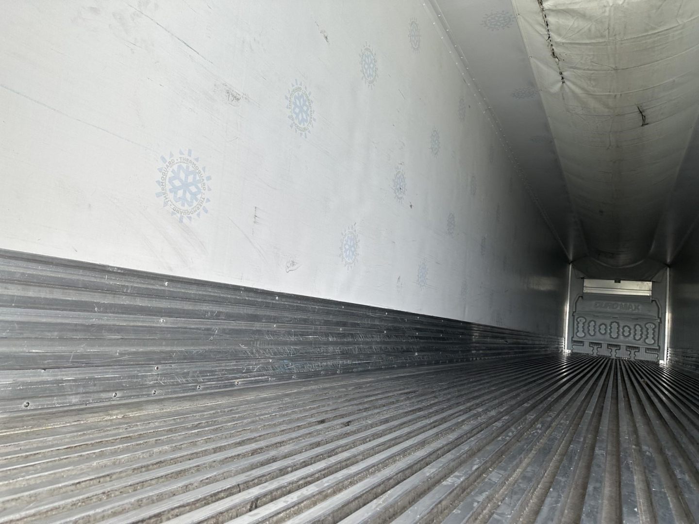 Interior of a used Great Dane air ride reefer trailer showing ribbed metal floor and insulated walls.