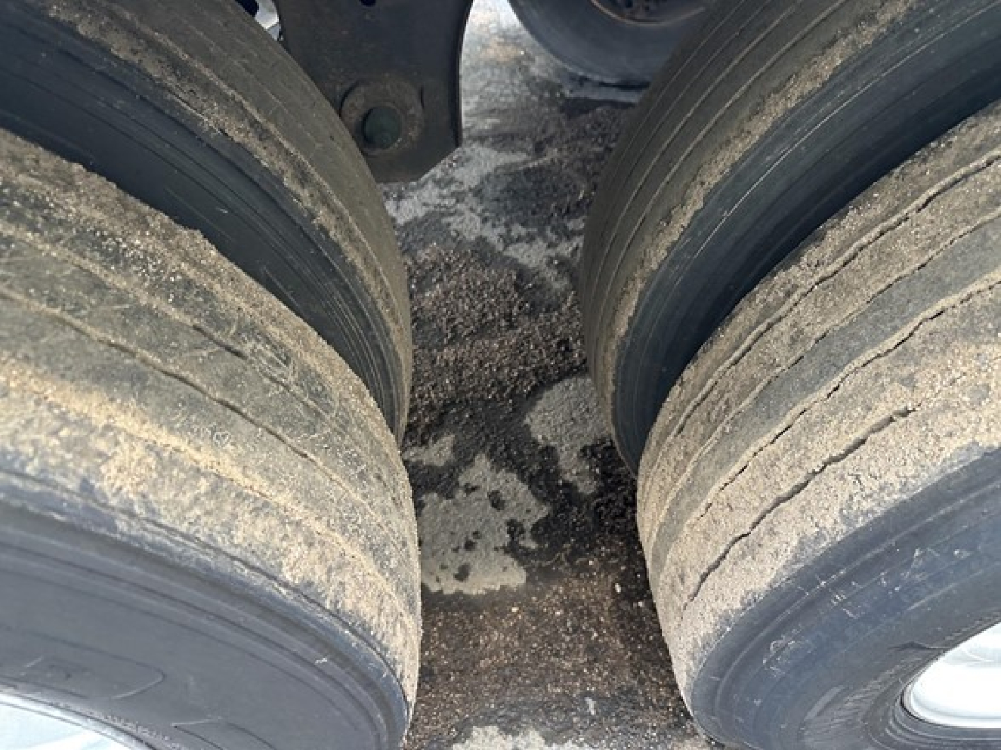 Two outer dual tires of a Great Dane trailer with dirt along the tread and residue near the hub area.