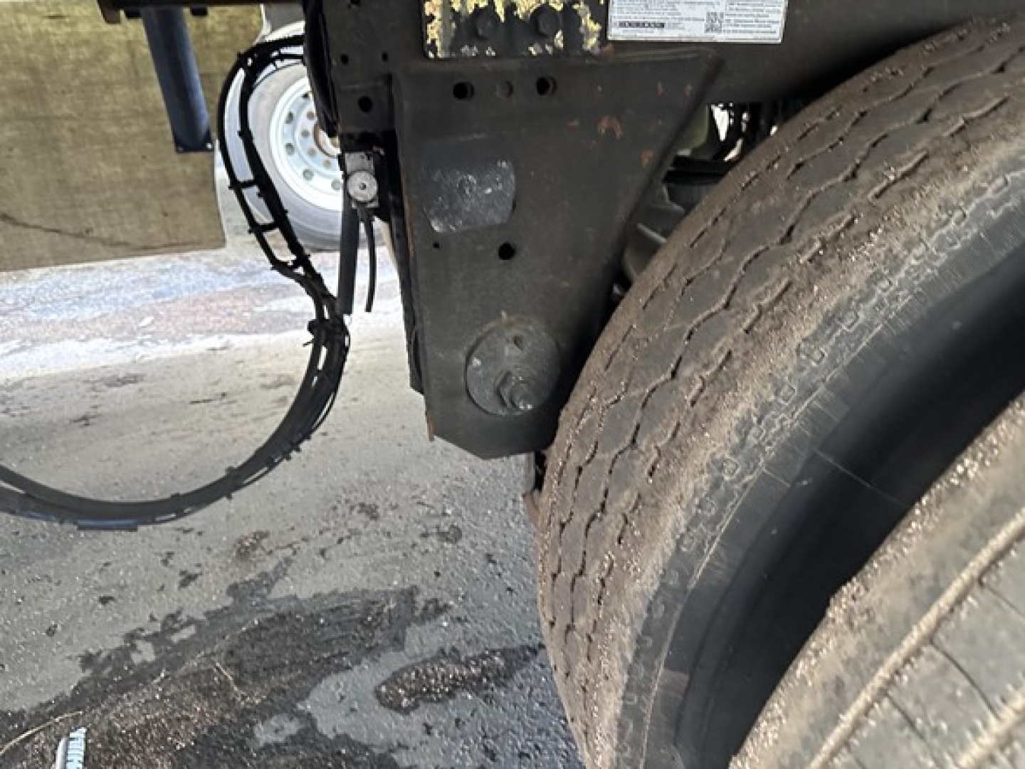 Great Dane carrier 7300 trailer wheel and frame close-up showing rear tire and suspension components with cables and a small sticker label.