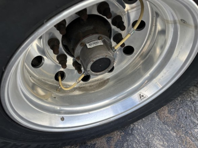 Great Dane carrier trailer wheel hub showing tire and axle components with valve stem and small label on hub.
