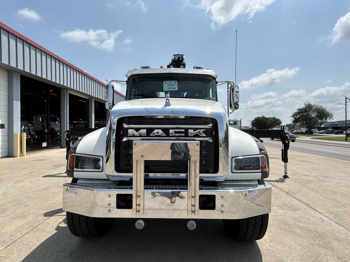 Mack GR64F crane truck front view showing large chrome bumper and grille with Mack logo in center.