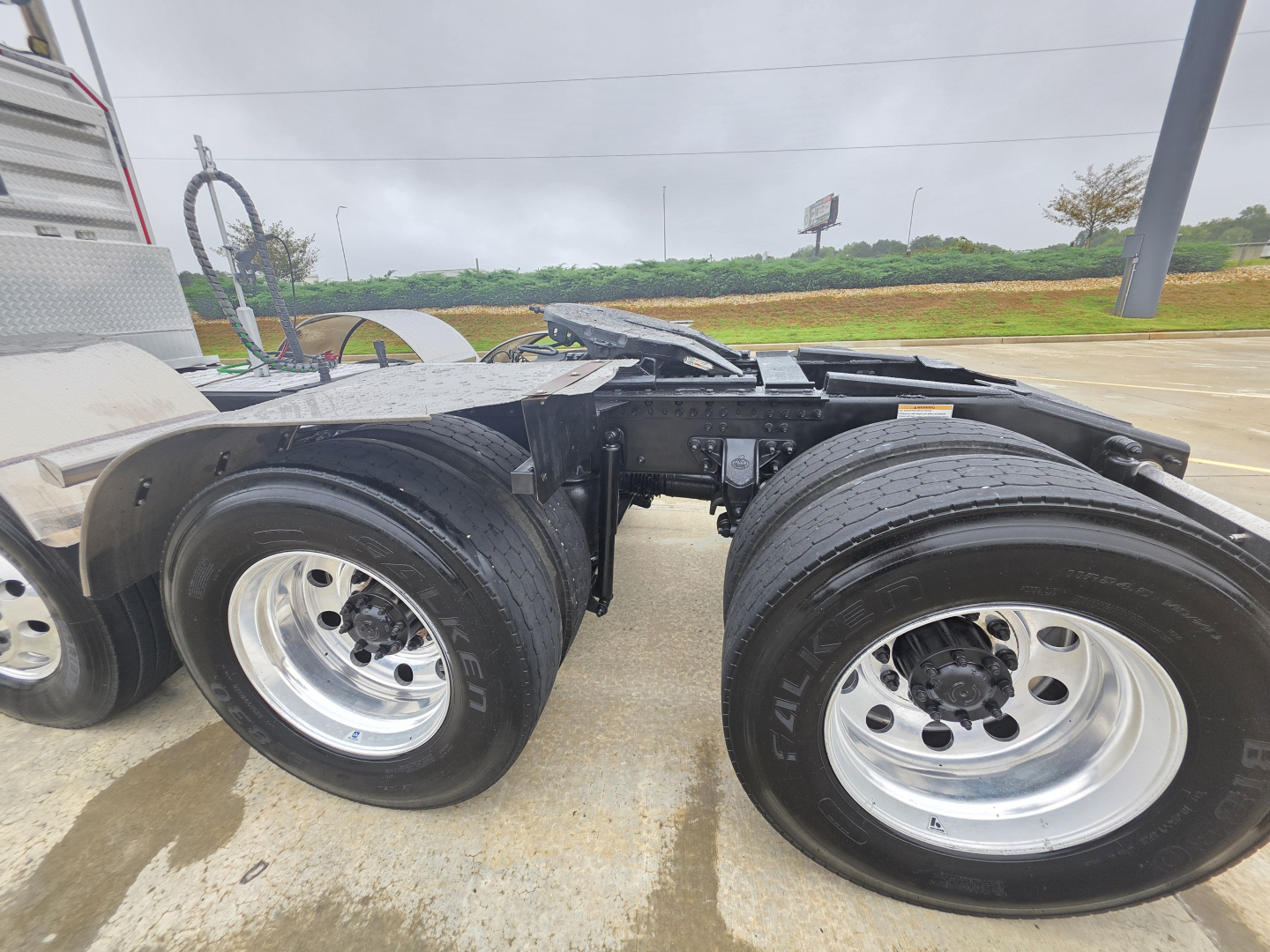 Dual rear axles on a Mack Pinnacle 64T tractor showing chrome wheels and black tires, chassis framing visible