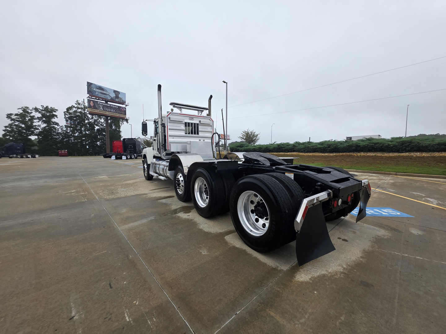 Mack Pinnacle 64T cab with dual rear axles and mudflaps, front view showing chassis and fifth wheel area.
