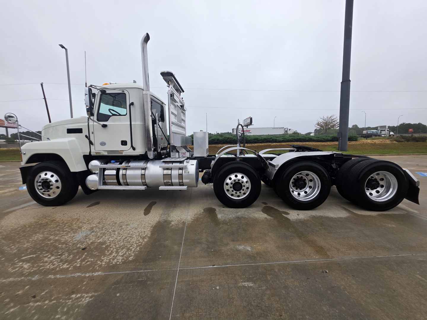 Mack Pinnacle 64T truck side view showing tandem rear axles and white cab.