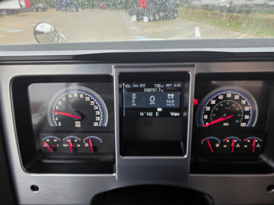 Dashboard of a Mack Pinnacle 64T showing instrument gauges and a central display. Left: speedometer with tachometer and smaller gauges. Right: additional gauges. Center: digital display panel.