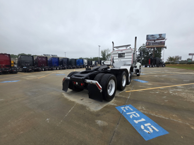Mack Pinnacle 64T highway tractor rear view showing fifth wheel and dual rear axles with white cab.