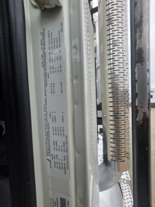 Label plate with specification data on Mack Pinnacle 64T truck door jamb showing weights and engine specs.