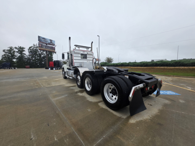 Mack Pinnacle 64T cab with dual rear axles and mudflaps, front view showing chassis and fifth wheel area.