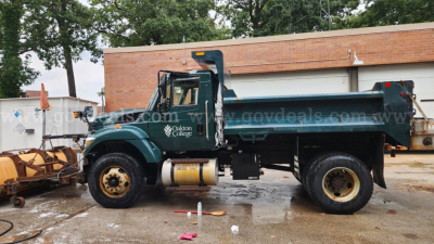 Truck bed view: green 2013 International 7400 dump truck with plow equipment, VIN 1HTWDAAR3DH466923, stock 13023-102, in-service vehicle.