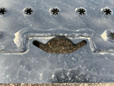 Trailer hitch area of a new Trail-Eze TE80Ht trailer showing metal surface with screws and a curved cutout near a hatch.