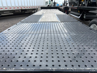 Trailers with perforated steel deck and central raised area, perspective view of a Trail-Eze TE80Ht flatbed trailer.
