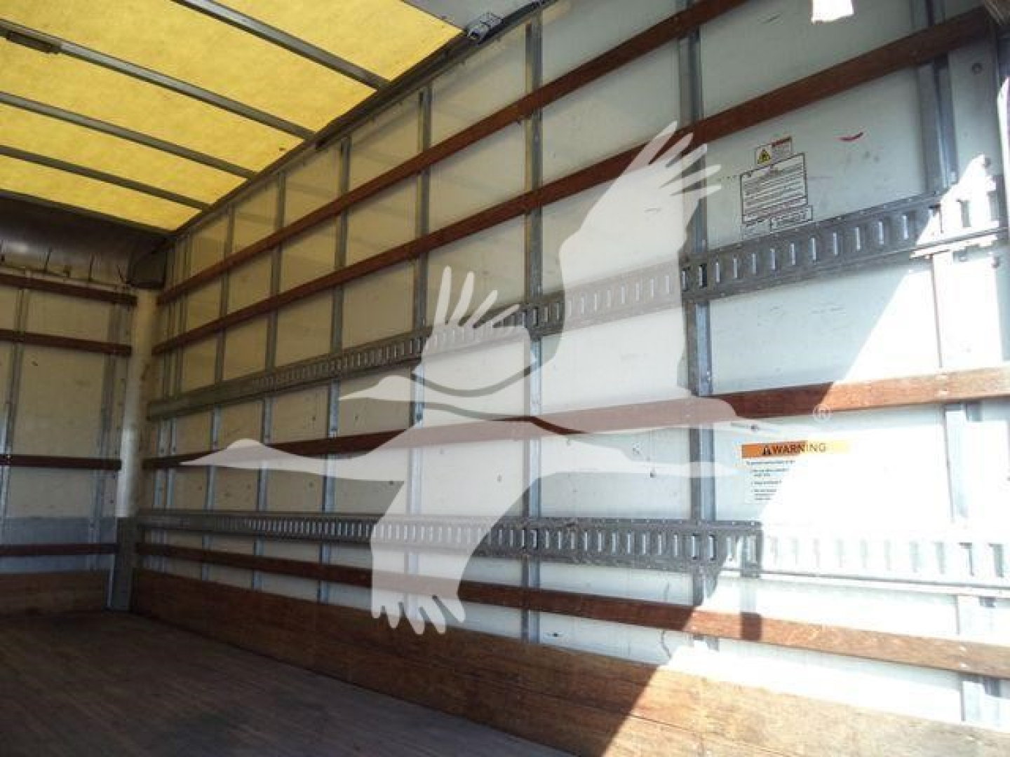 Isuzu NPR-HD box truck cargo area with bare interior walls and overhead rails; no visible engine or exterior details.