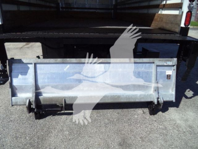 Isuzu NPRHD truck tailgate/dump body with metal plate and hydraulic latch, side view. Visible text: none legible.
