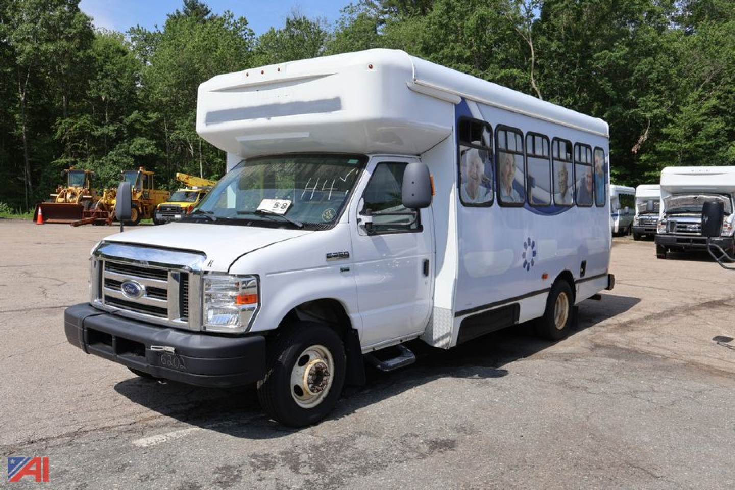 Ford E-350 shuttle bus with wheelchair lift, white body, side windows, front view, used vehicle.