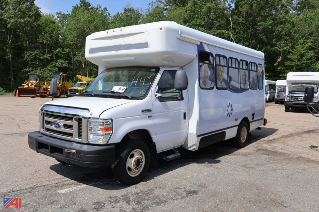 Ford E-350 shuttle bus with wheelchair lift, white body, side windows, front view, used vehicle.