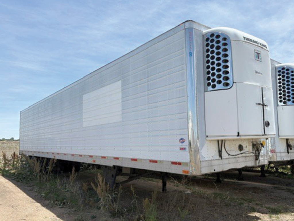 Trailer showing Thermo King reefer unit at the front, side panel with light reflection, utility 3000R trailer in yard.