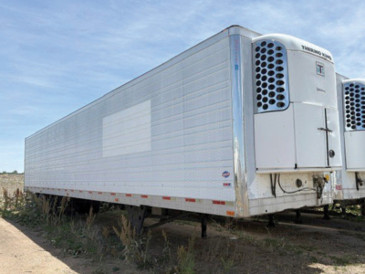 Trailer showing Thermo King reefer unit at the front, side panel with light reflection, utility 3000R trailer in yard.
