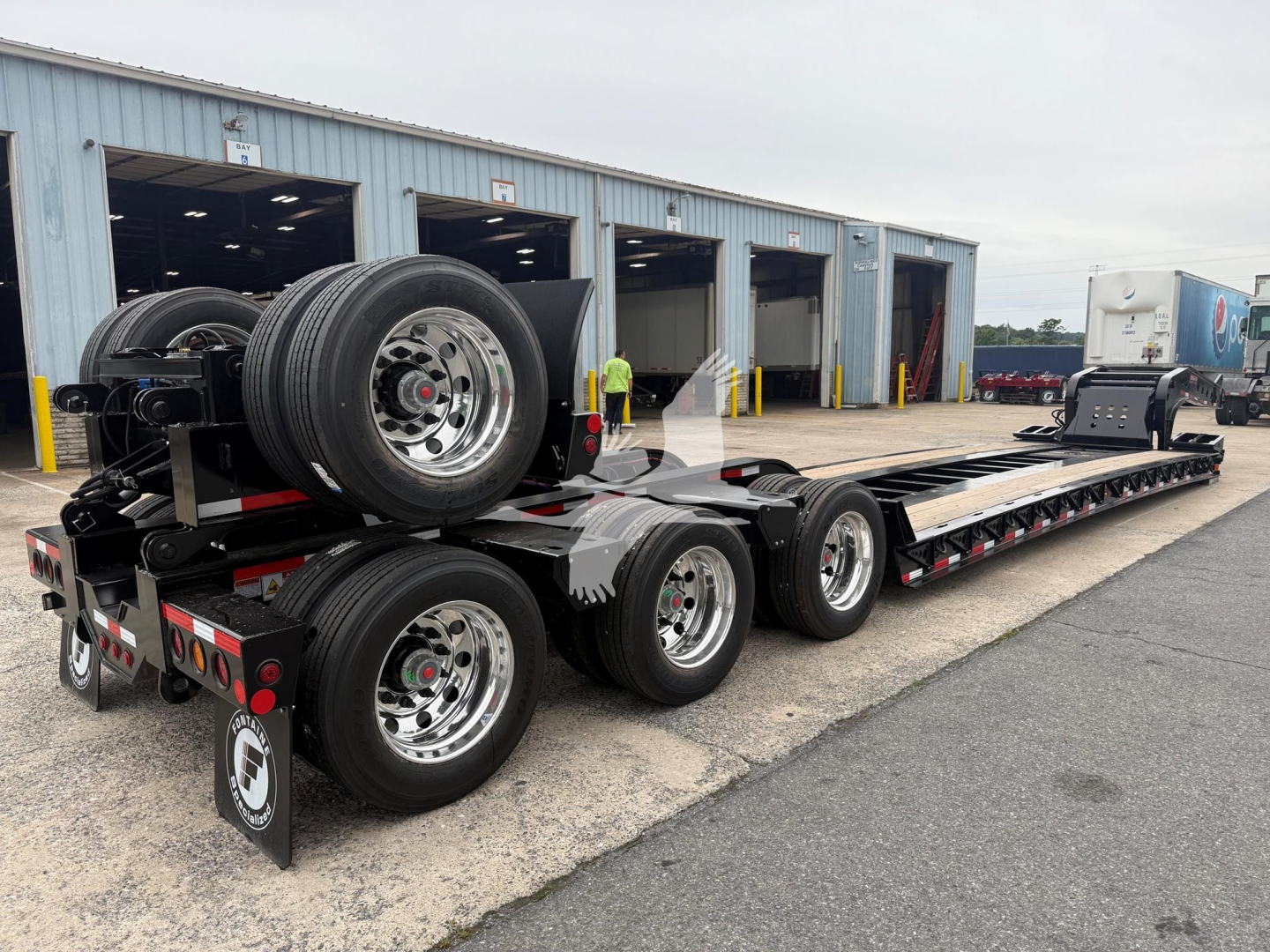  Fontaine Magnitude 60Lcc trailer in a yard showing dual rear axles and gooseneck? Not exactly. [Image depicts a lowboy trailer with multiple axles and spare tires at the rear]