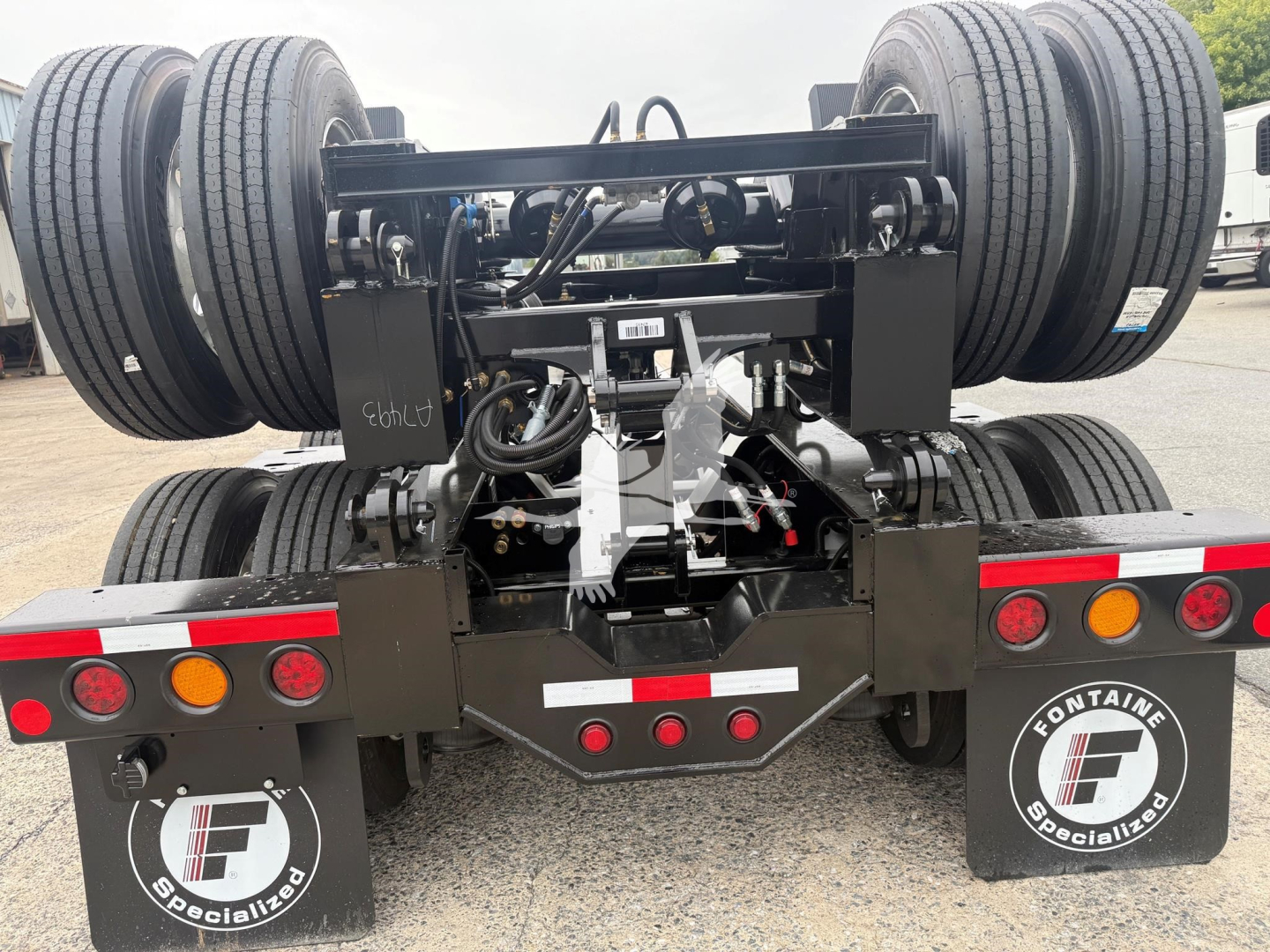 Trailer rear showing fifth wheel hitch and dual rear axles with heavy-duty suspension on Fontaine Magnitude 60Lcc lowboy trailer.
