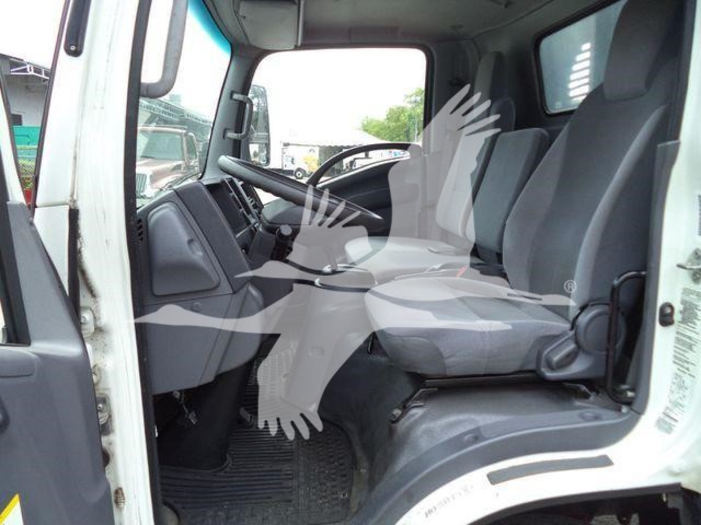 Isuzu NRR truck cabin interior showing driver and passenger seats, dashboard, and steering wheel.