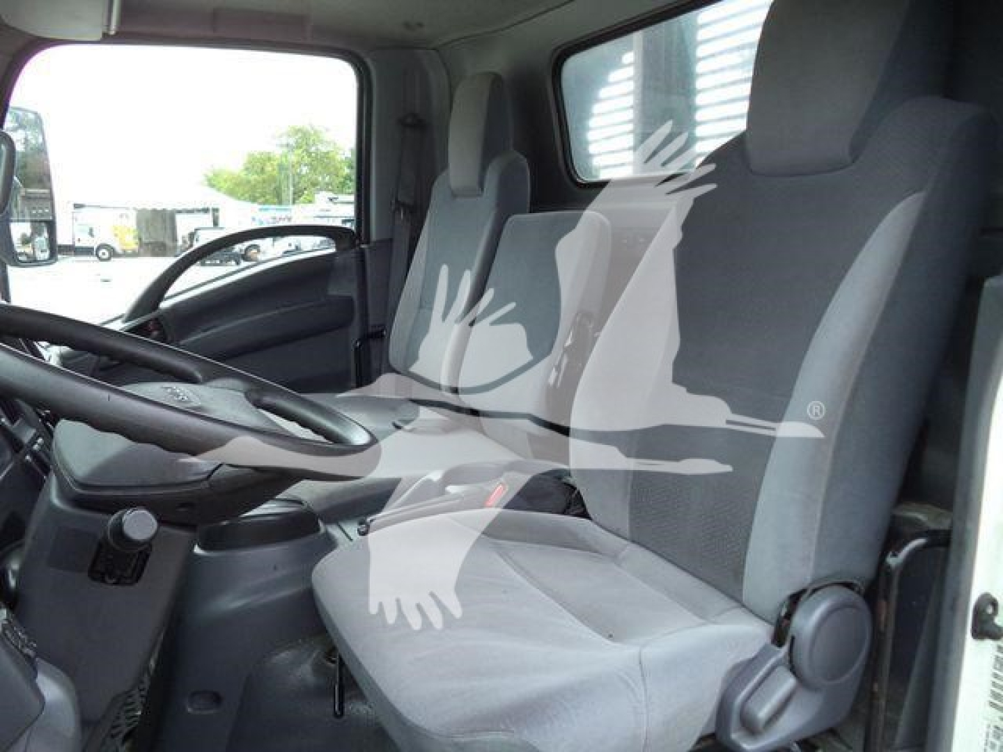 Isuzu NPRR truck interior showing driver seat and passenger seat in cab with steering wheel and dash visible.