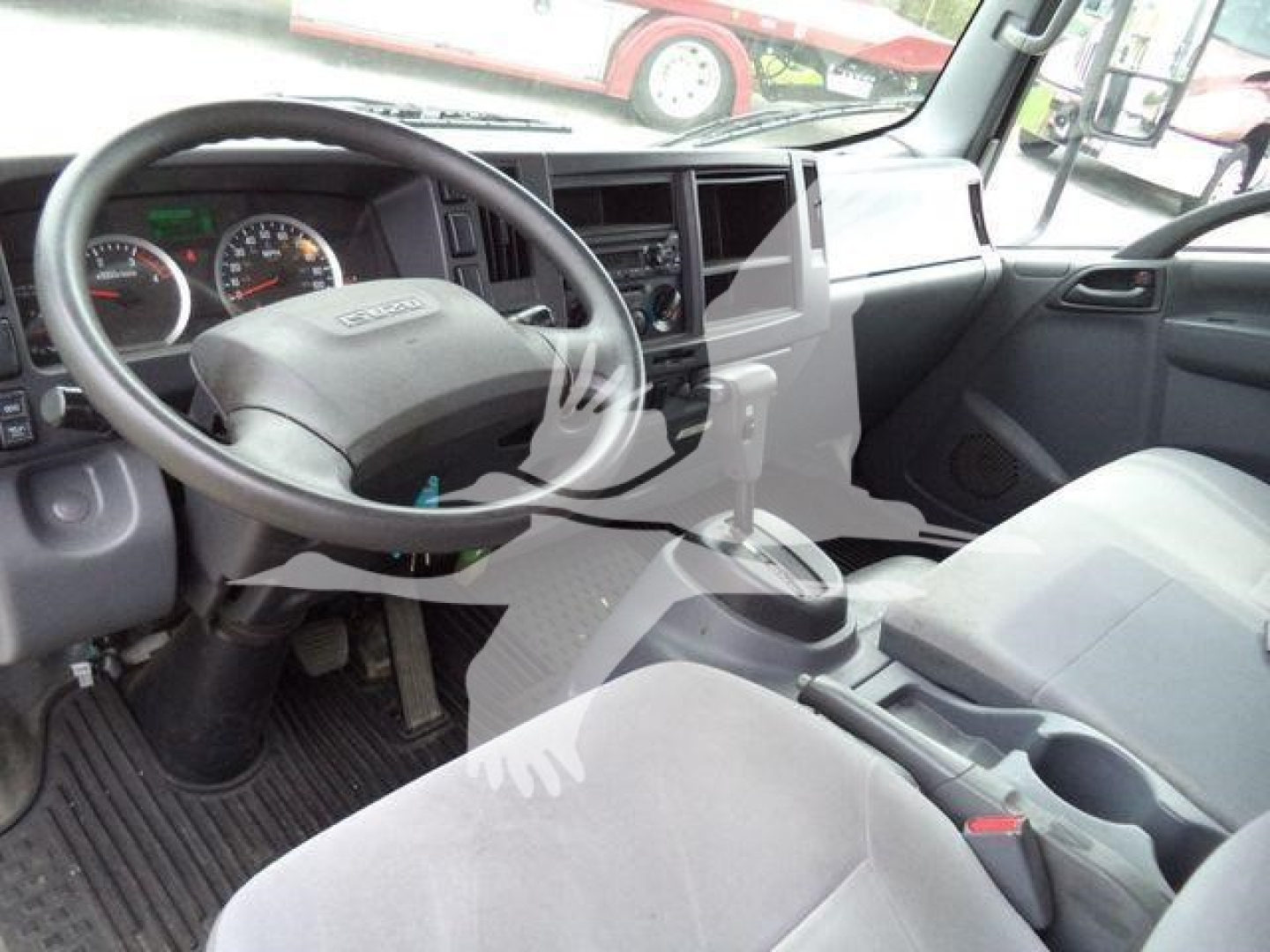 Isuzu NPR/Nrr interior showing steering wheel, dashboard gauges, center console, gear shift, and front seats.