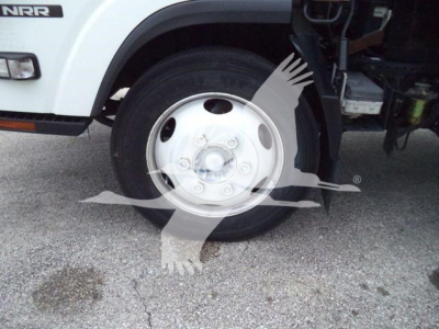 Isuzu NRR front wheel well showing steel wheel and tire, with white cab and NRR badge visible.