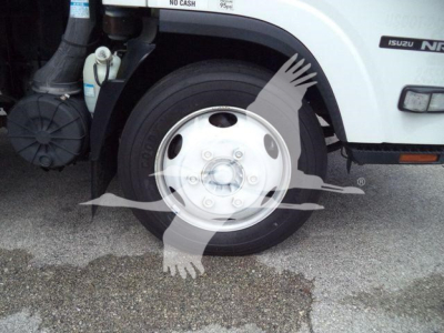Isuzu NPR truck front wheel and fender with tire and wheel cover visible.