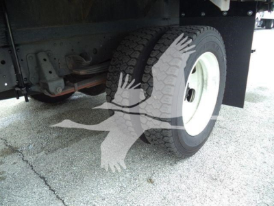 Isuzu truck rear dual tires and undercarriage view showing wheel and suspension components.