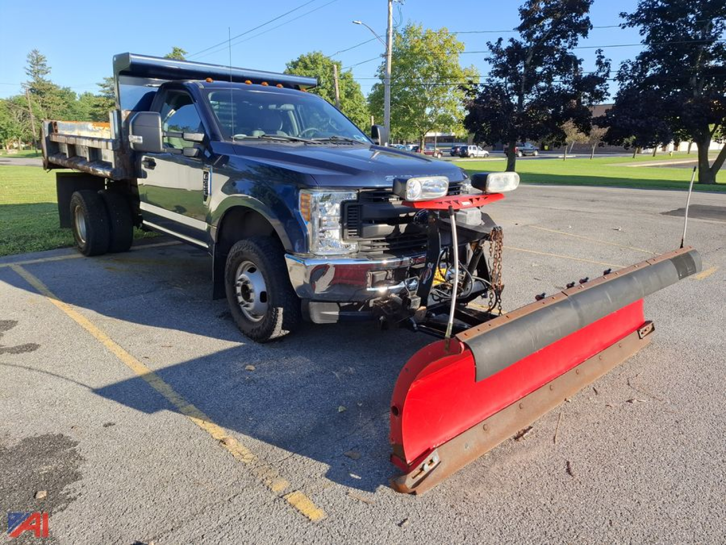 Ford F-350 Super Duty dump truck with plow attachment in front, black crew cab, utility bed, snow plow bladepan.
