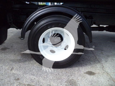 Wheel and fender area of a 2017 Hino 258LP hooklift truck showing rear dual wheels and black tire with white hub, undercarriage visible.