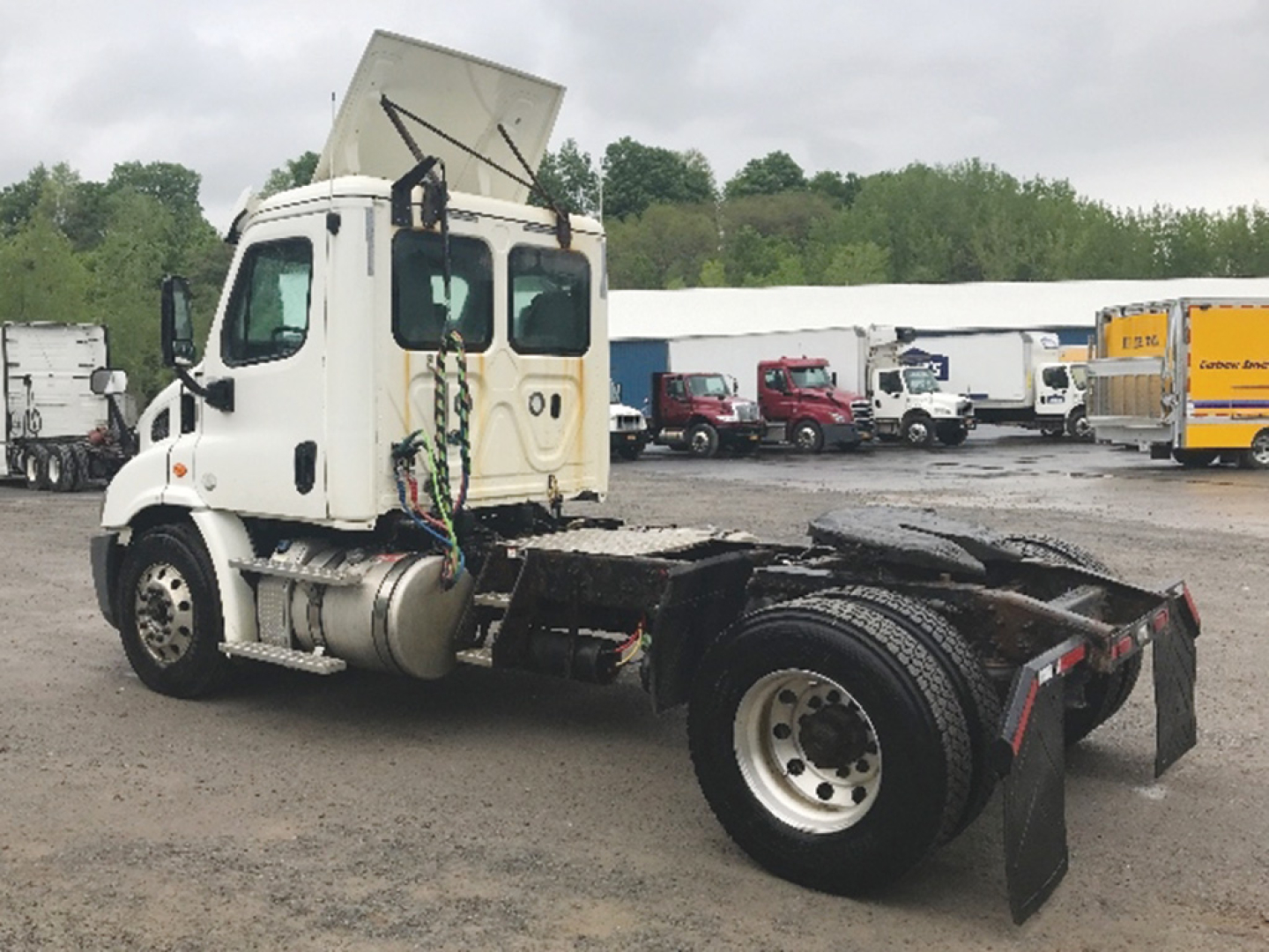 Truck chassis showing Freightliner Cascadia cab and bare rear frame with wheel and mudflaps.