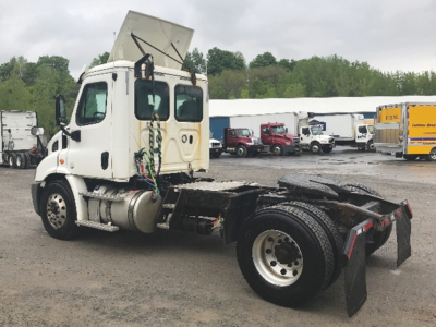 Truck chassis showing Freightliner Cascadia cab and bare rear frame with wheel and mudflaps.