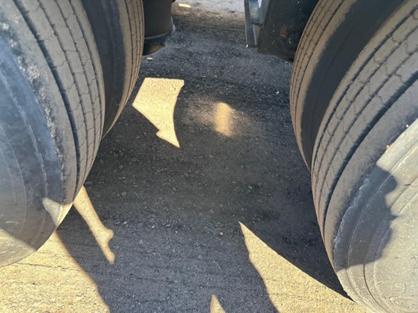 Lowboy trailer wheels showing dual tires and a gap between axles.