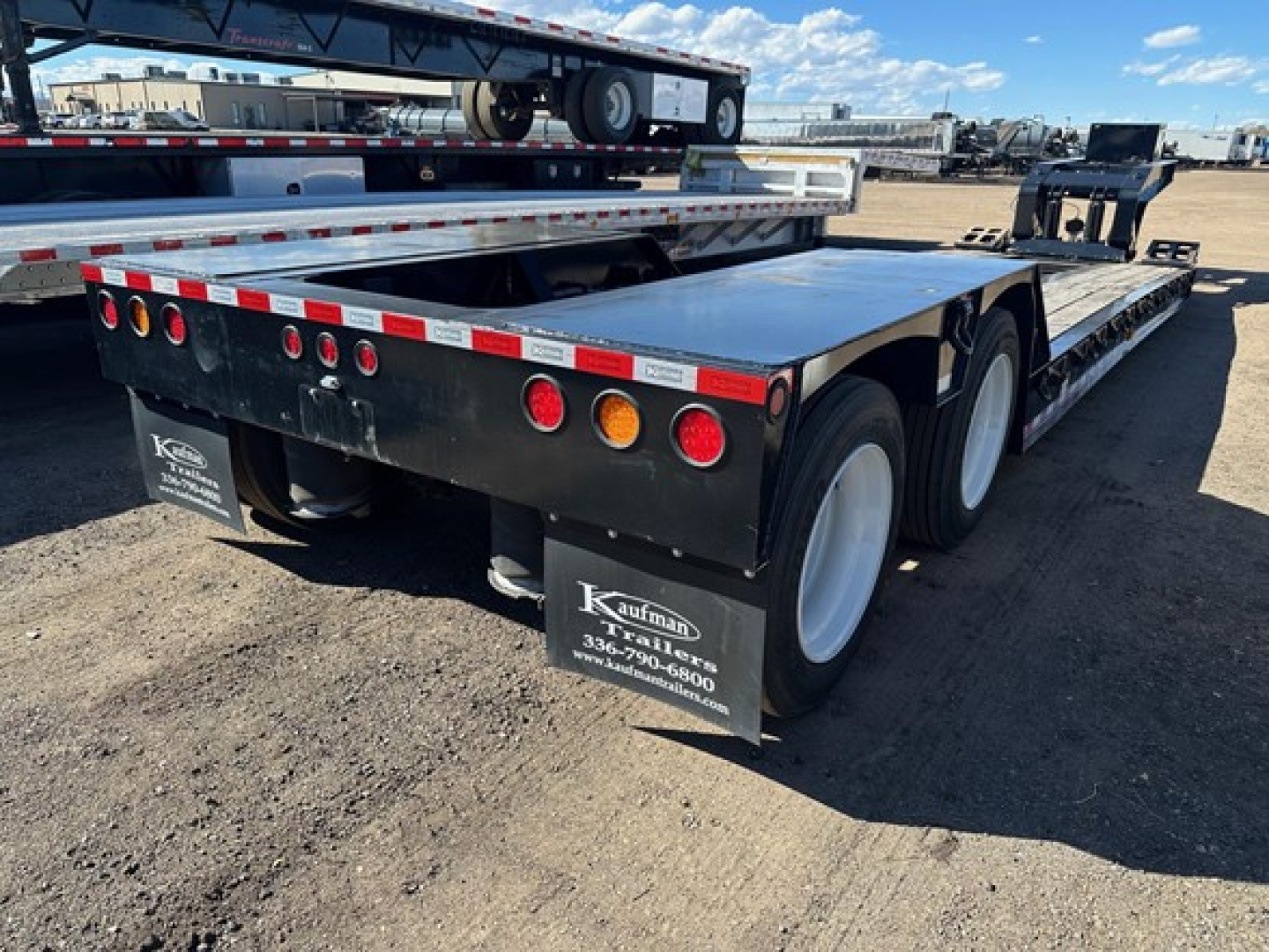 Kaufman lowboy trailer rear view showing dual rear axles and taillights with Kaufman Trailers branding