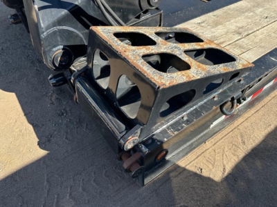 Lowboy trailer rear showing rusted toolbox on deck and loading ramps with attachment hardware.