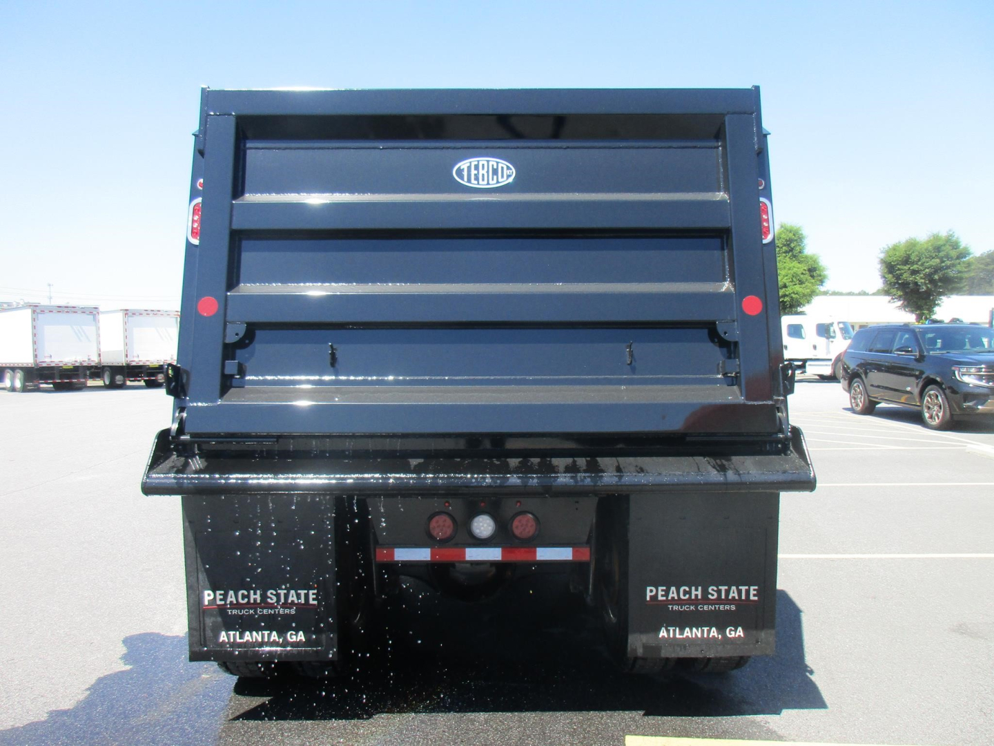 Dump truck bed showing TEBCO logo on tailgate and Peach State license area in Atlanta, GA.