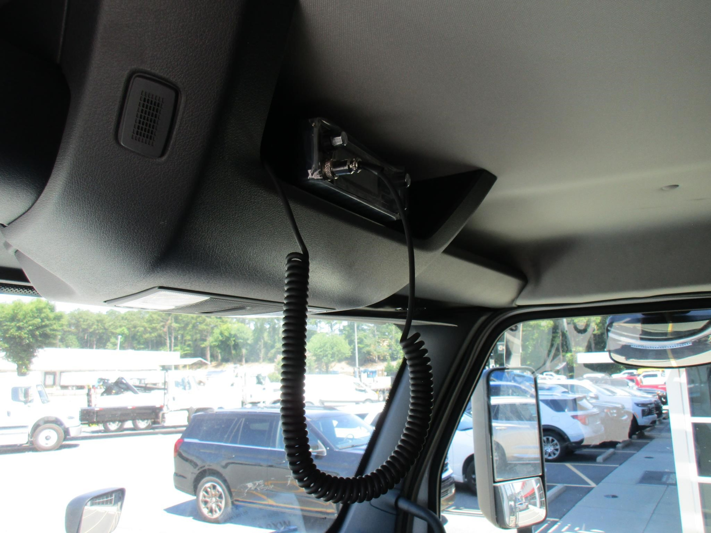 Interior view of a new Western Star 47X cab with a mic/handset wired clip and overhead mount, showing cockpit area and windshield