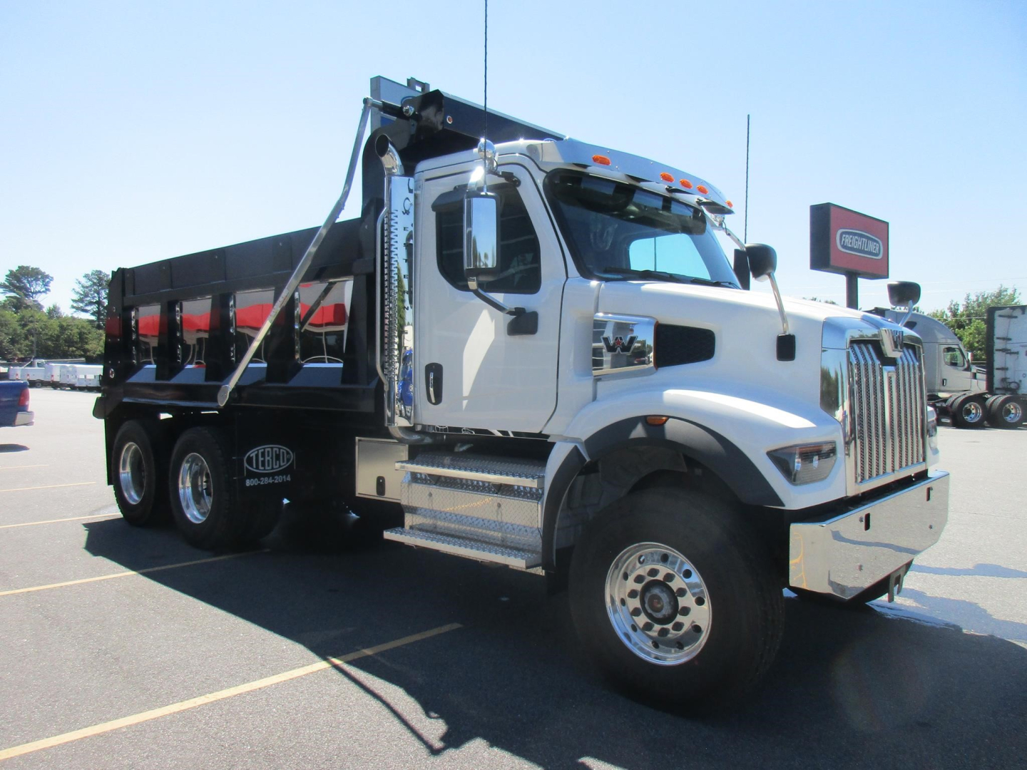 Dump truck with white cab and black dump body, side view showing Western Star 47X. VIN plate visible? Stock number 342925 not legible. Side steps and chrome bumper visible.