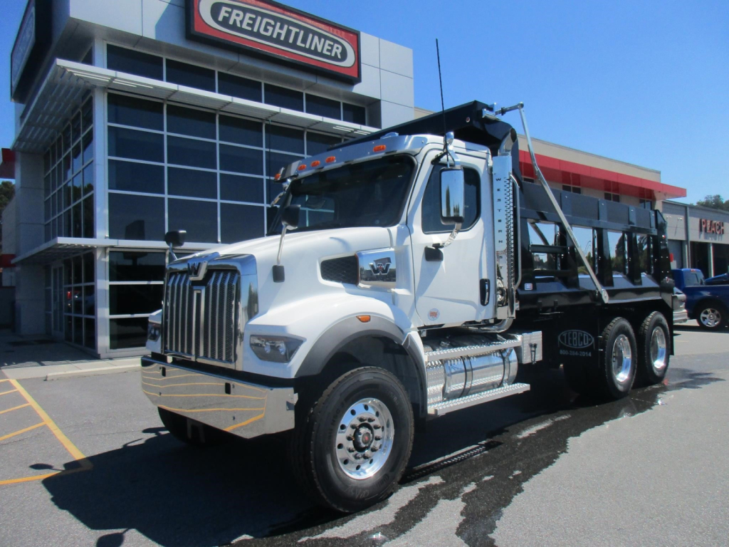 Dump truck in front of a dealership showing Western Star 47X cab and Ram dump bed with chrome fuel tanks