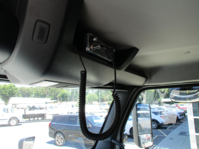 Interior view of a new Western Star 47X cab with a mic/handset wired clip and overhead mount, showing cockpit area and windshield