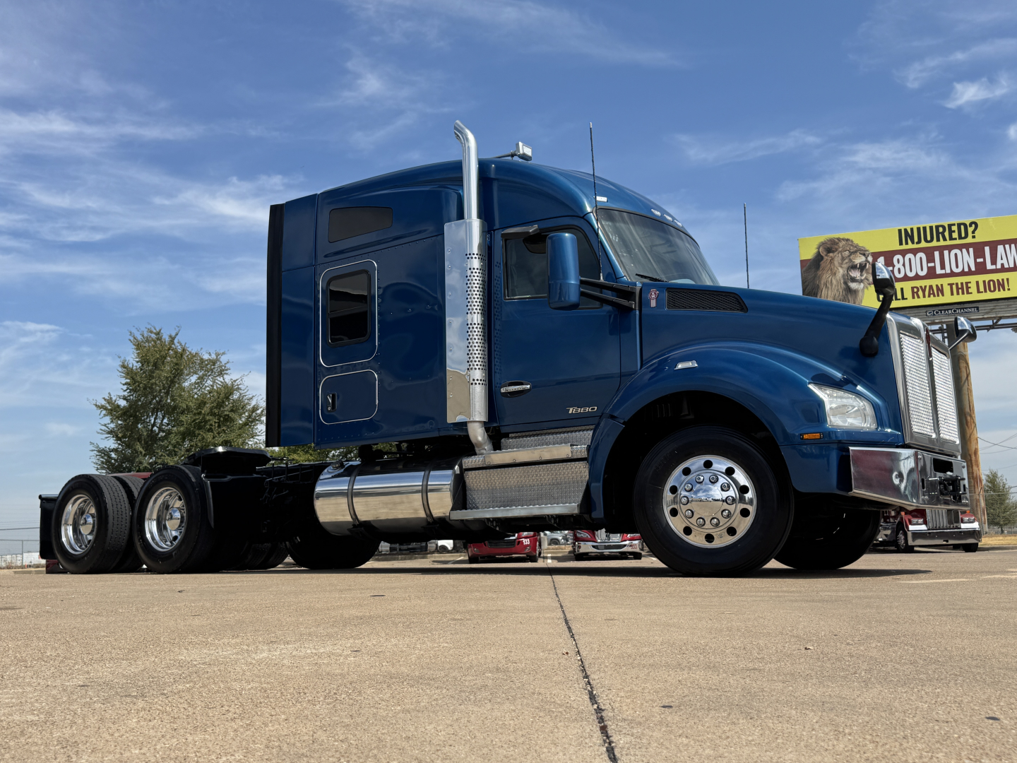 Kenworth T880 cab over engine bay showing chrome fuel tanks and dual rear axles.