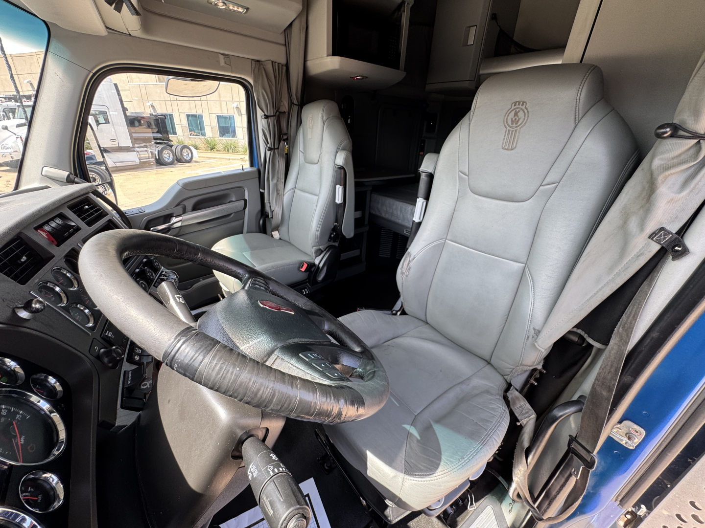 Kenworth T880 truck interior showing steering wheel, seat upholstery, and cabin area with driver and passenger seats visible