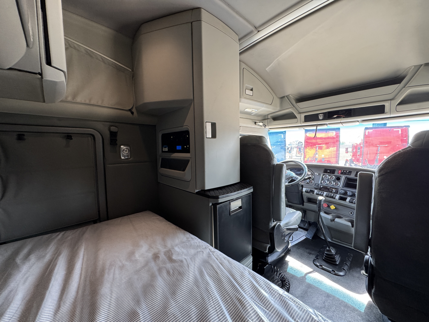 Kenworth T880 truck cab interior with sleeper area and dashboard; visible text includes VIN 1XKZDP9X1KJ244116 and stock number 0632205.