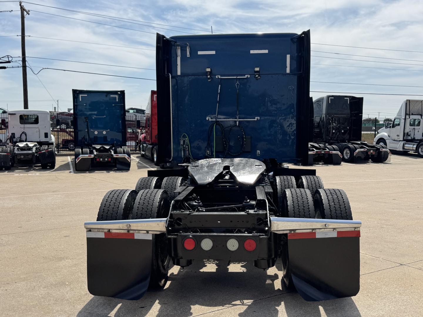 Kenworth T880 rear view showing dual rear axles and fifth-wheel attachment area with mud flaps and rear bumper.