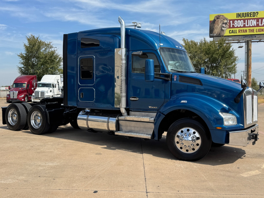 Kenworth T880 conventional sleeper truck in blue, side view with chrome exhaust stacks and fuel tanks.